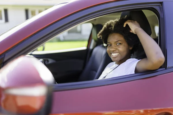 Young black woman sit on is first red car — Photo