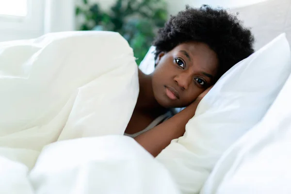 Beautiful young African woman in tank top lying in bed sleeping — Fotografia de Stock