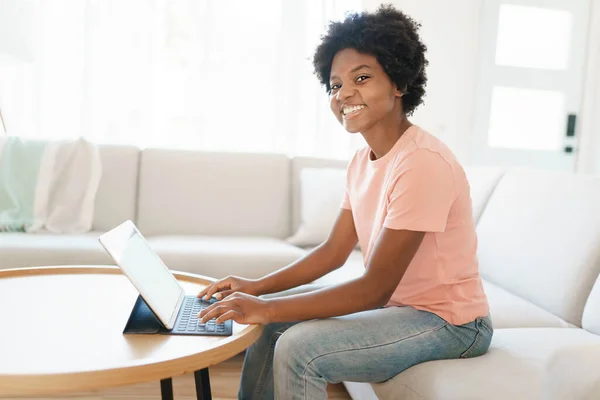 Attraktiv ung kvinna som arbetar med tablett på soffan — Stockfoto