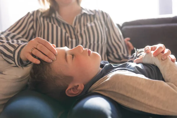 Son with problem sit on the mother knee — Zdjęcie stockowe