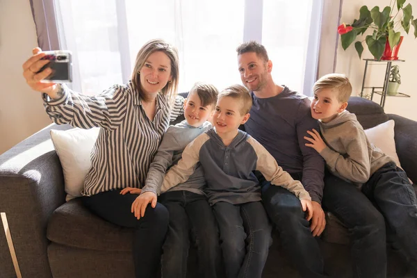 Семья из пяти человек отдыхает вместе на диване видеозвонок с семьей — стоковое фото