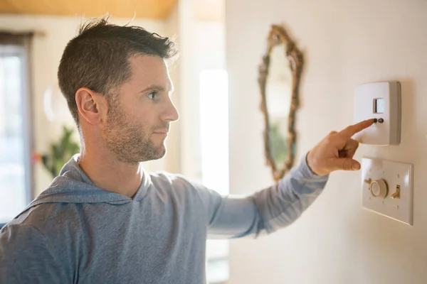 Netter Mann stellte das Thermostat am Haus ein — Stockfoto