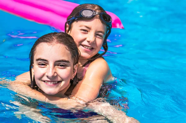 两个姐姐夏天在游泳池玩得很开心 — 图库照片
