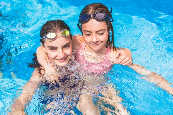 Two sister having fun in Pool on the summer time — Stock Photo, Image