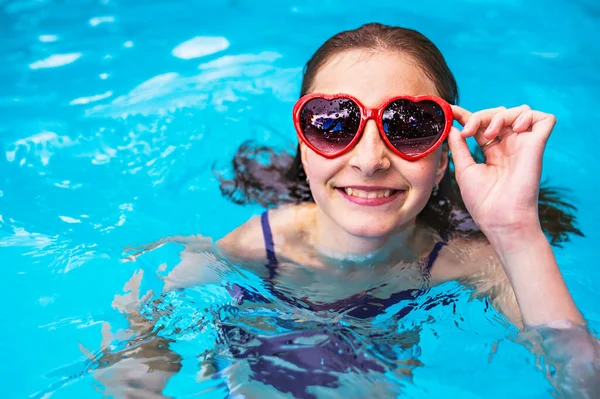 Child girl holding beach ball having fun on Pool with heart glasses on the summer time — Stock Photo, Image