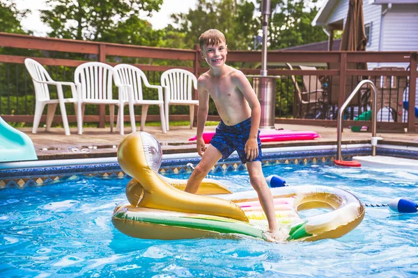 Menino se divertindo na piscina na hora de verão — Fotografia de Stock