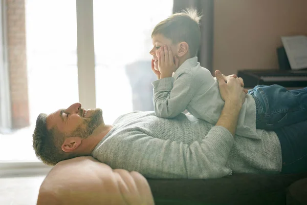 Padre o Padrino divirtiéndose relajándose en la sala de estar en casa — Foto de Stock