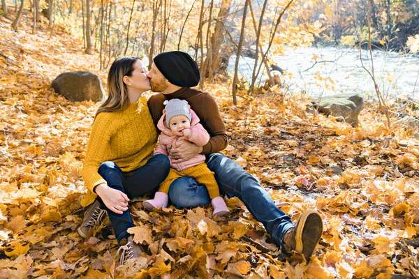 Kleine dochter en haar ouders in het najaar in het park — Stockfoto