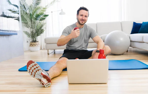 Attractive Fit man Exercise at home on the living room with apple on hand — Stock Fotó
