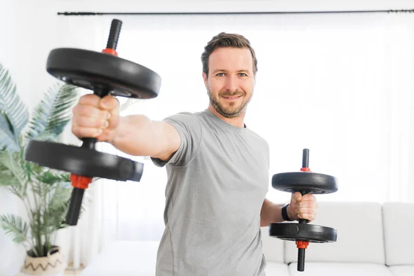 Attractive Fit man Exercise at home on the living room with dumbell on hand — Stock Fotó