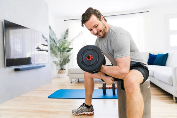 Attractive Fit man Exercise at home on the living room with dumbell on hand — Stock Fotó