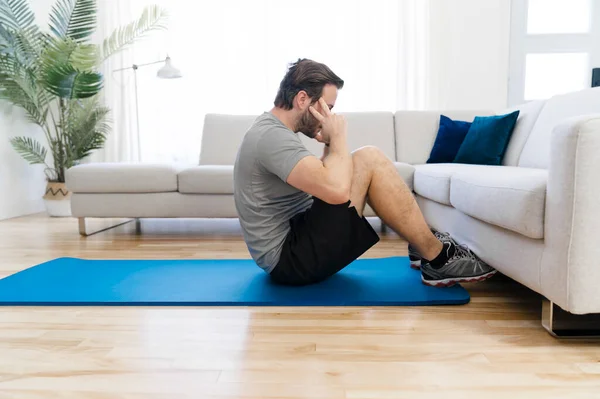 Attractive Fit man Exercise at home on the living room — Stock Fotó