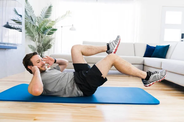 Attractive Fit man Exercise at home on the living room — Stock Fotó