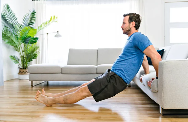 Attractive Fit man Exercise at home on the living room — Stock Fotó