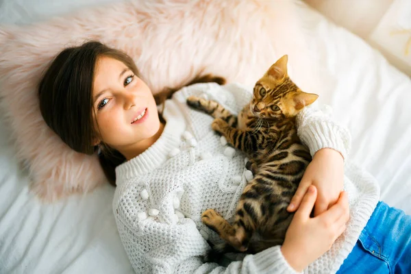 Bengal cat in the bed room with child girl — Stockfoto