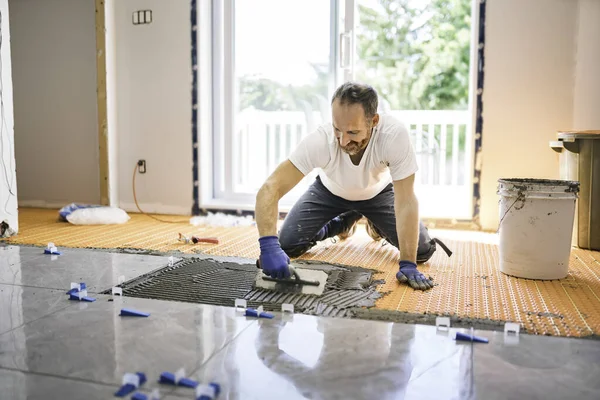 Nice handyman install tile on the floor — Stockfoto