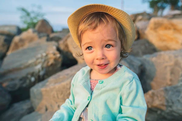 Baby outdoors enjoying nature on the sunset beach with hat — Stock fotografie