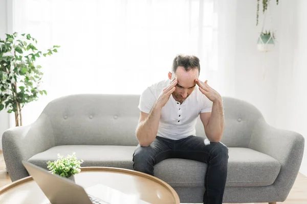 Frustrated handsome man with problem sitting on the couch at home — Foto Stock