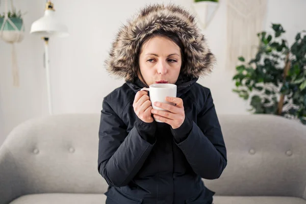 Woman With coffee and Warm Clothing Feeling The Cold Inside House on the sofa — Photo