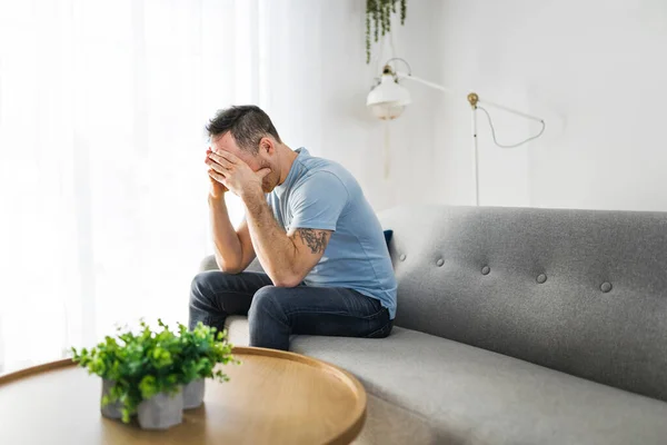 Sad young man in the living room — Stockfoto