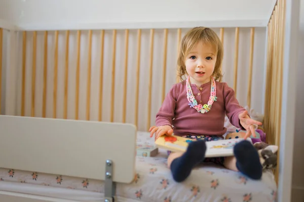 Petite fille lire livre dans la chambre à coucher à la maison — Photo