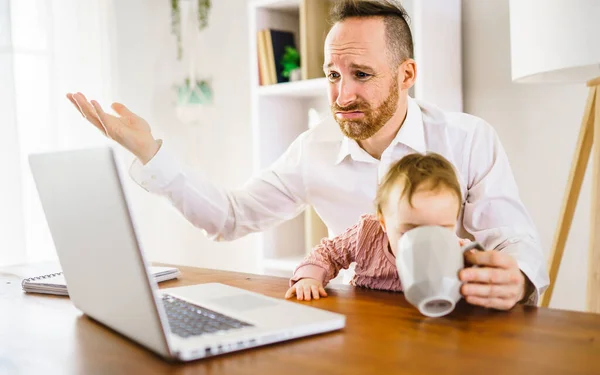 Triste e frustrado pai na cozinha home office com computador e sua filha — Fotografia de Stock