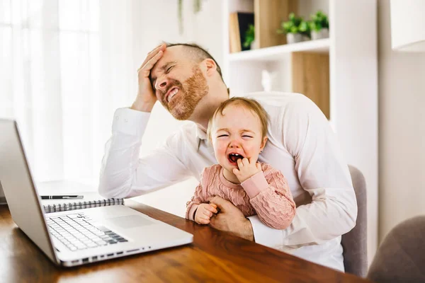 sad and frustrated father in kitchen home office with computer and her daugher