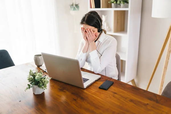 Frustrated and sad woman working on laptop at home — Stockfoto