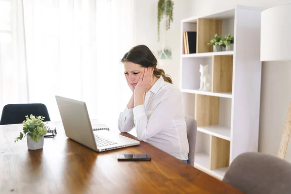 Frustrated and sad woman working on laptop at home — Stock Fotó