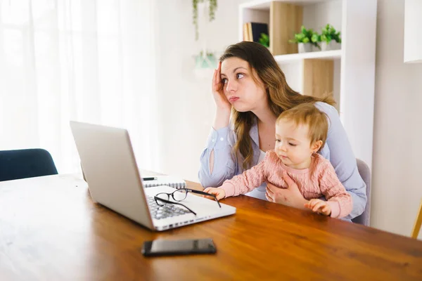 Triste e frustrada mãe na cozinha home office com computador e sua filha — Fotografia de Stock