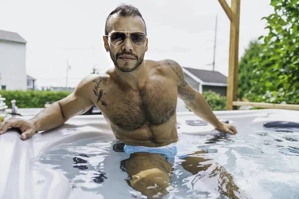sexy mexican man relaxing in hot tub on summer season