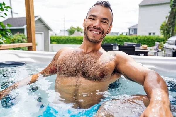 sexy mexican man relaxing in hot tub on summer season