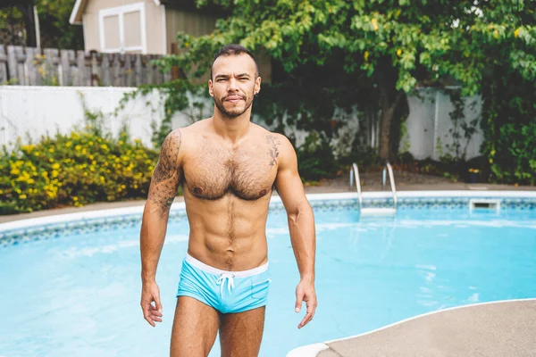 Mladý mexický a sexy svalnatý muž pózující v bazénu — Stock fotografie