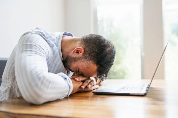 Portrait of a sad and depress mexican businessman working at modern home office with computer laptop — Foto de Stock