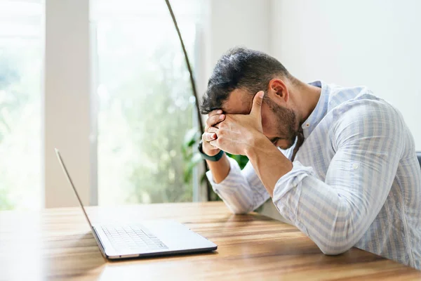 Retrato de un triste y deprimido hombre de negocios mexicano que trabaja en la moderna oficina en casa con computadora portátil —  Fotos de Stock