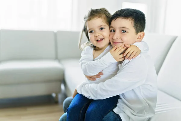 Hermano y hermana divirtiéndose en el sofá en casa —  Fotos de Stock