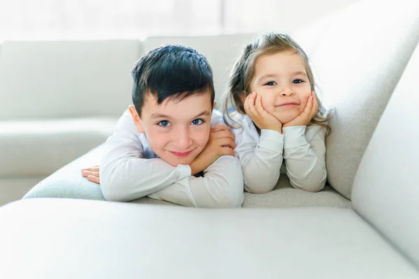Брат і сестра розважаються на дивані вдома — стокове фото