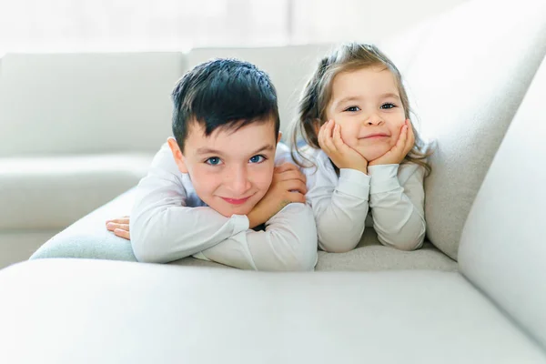 Hermano y hermana divirtiéndose en el sofá en casa —  Fotos de Stock