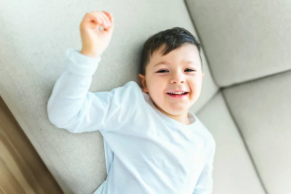 Kleiner verrückter Junge im Wohnzimmer sieht aus wie hyperaktiv — Stockfoto