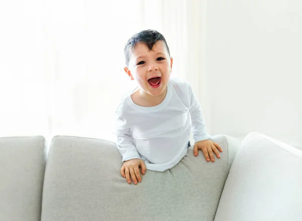 Pequeno menino louco na sala de estar olhar como hiperativo — Fotografia de Stock
