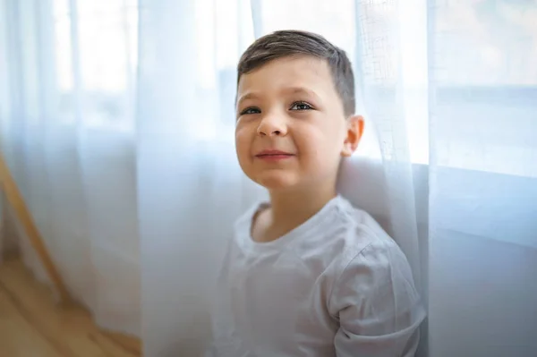 Kid on the living room at home close to a window — стоковое фото