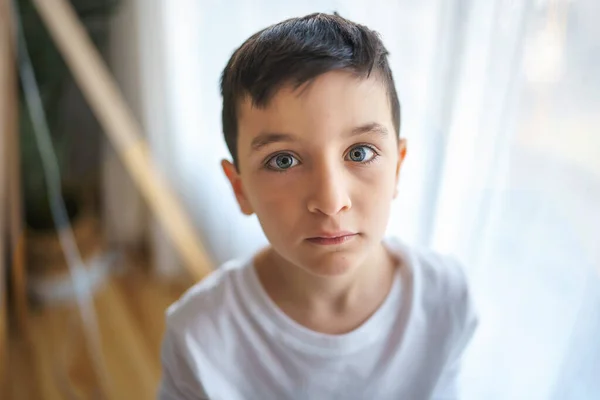 Niño en la sala de estar en casa cerca de una ventana — Foto de Stock