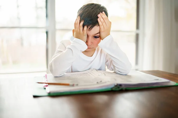 Denkend kind verveeld en gefrustreerd en genoeg van het doen van zijn huiswerk — Stockfoto