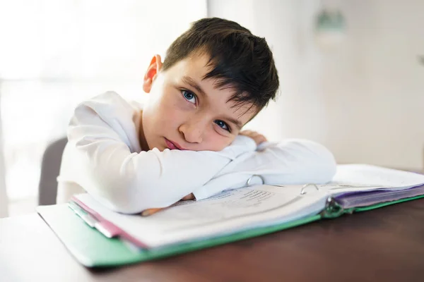 Thinking child bored and frustrated and fed up doing his homework — стоковое фото