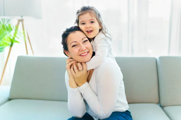 Mother with her daughter having fun in living room at home — стокове фото