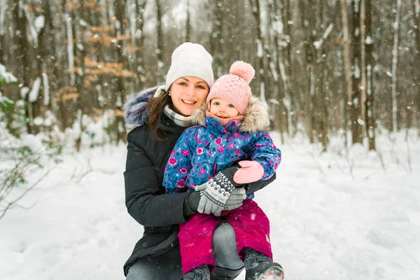 Adorable niña divirtiéndose en el día de invierno con la madre — Foto de Stock