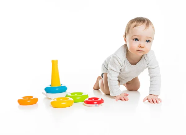 Baby girl on floor playing with color toy isolated on white background. — Stockfoto