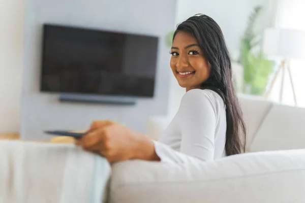 Black woman watching television at home sit on sofa — Fotografia de Stock