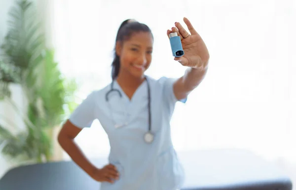 Young doctor holding asthma inhaler in clinic — Stock Photo, Image