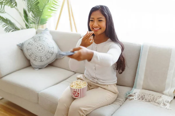 Woman eating popcorn watching favorite television show sitting cozy couch — Fotografia de Stock